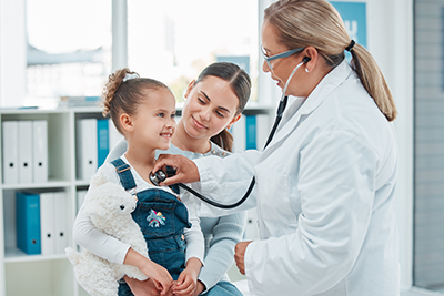 Professional doctor in white uniform gown coat and child patient discussing consultation with adult