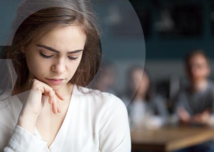 Young woman isolated from others looks unhappy