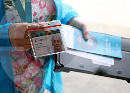 A CSO Household Survey Interviewer shows her official ID badge on the doorstep of a home